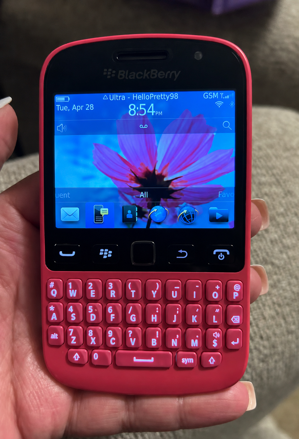 Pink BlackBerry smartphone held in a hand 